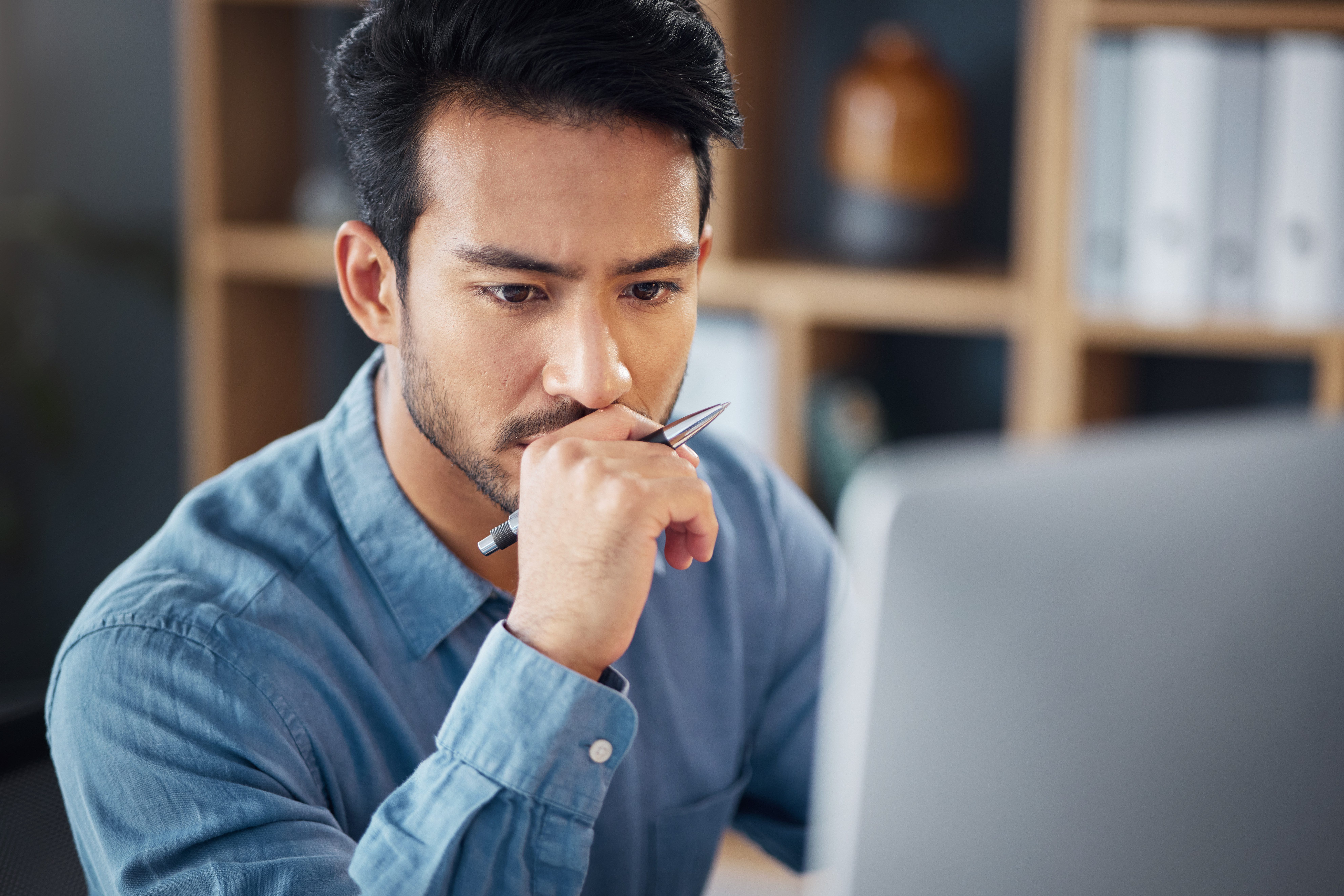 Serious, business man and thinking on computer in office, internet research and website. Focused male employee, desktop and solution of ideas, planning decision and review strategy, project or vision.