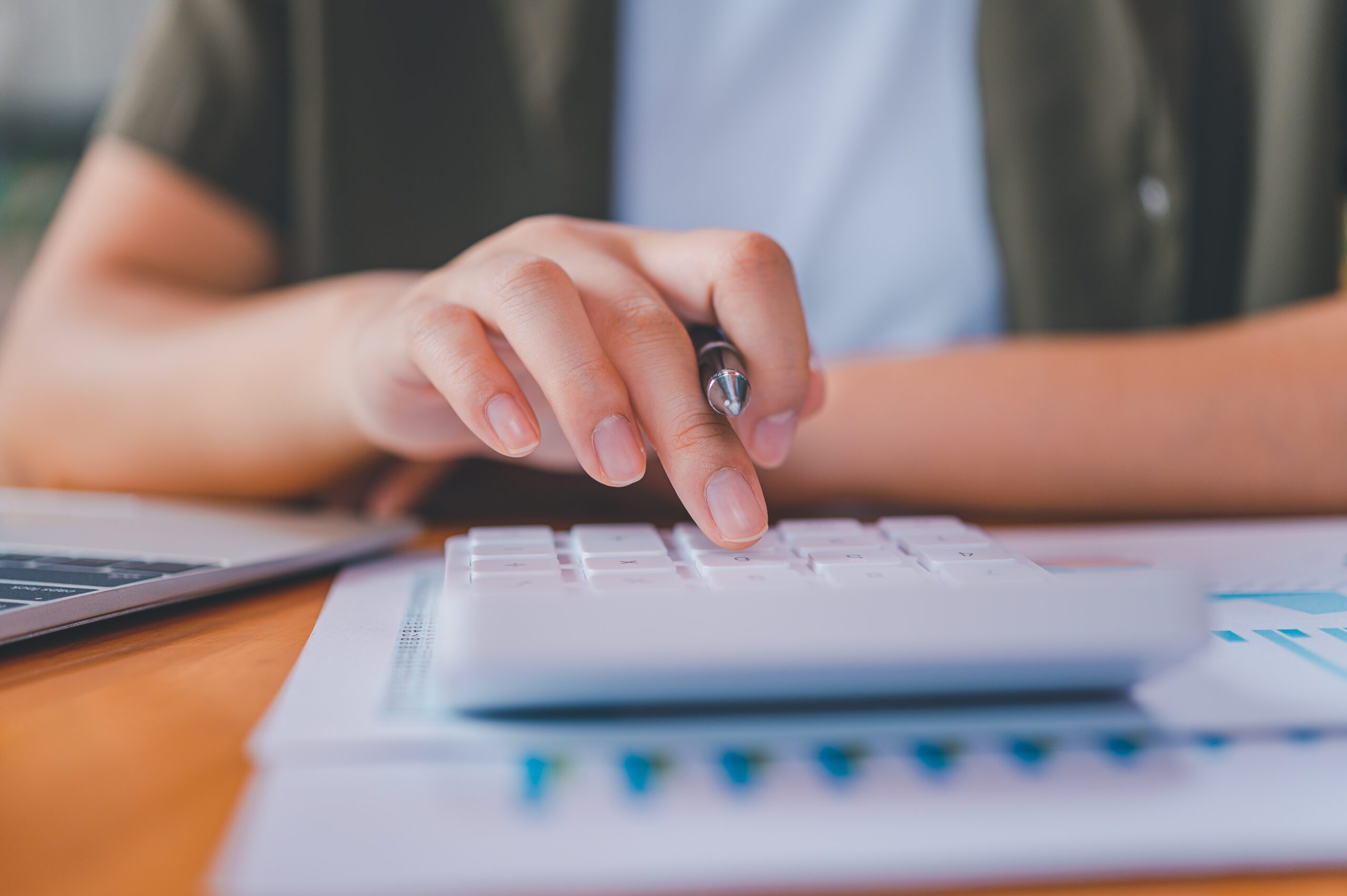 business person sitting at a desk at an office By using the calculator to work. Business Concept Analysis and Planning