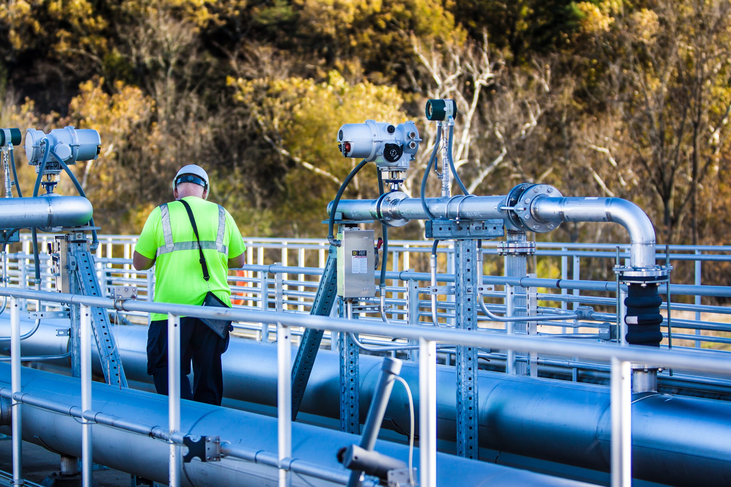 Technician inspecting wastewater processing plant pipelines