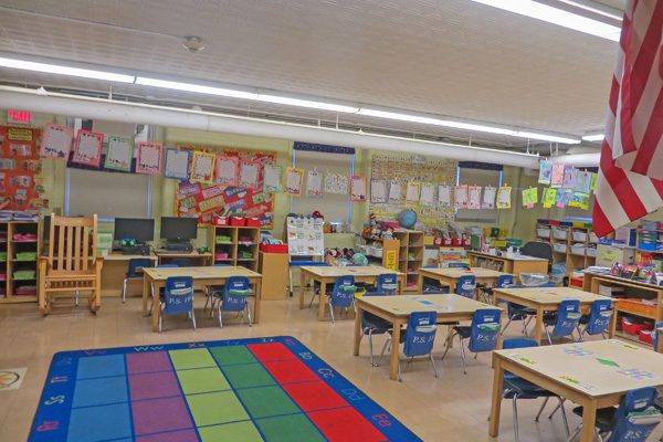 Colorful elementary classroom with student desks and learning tools